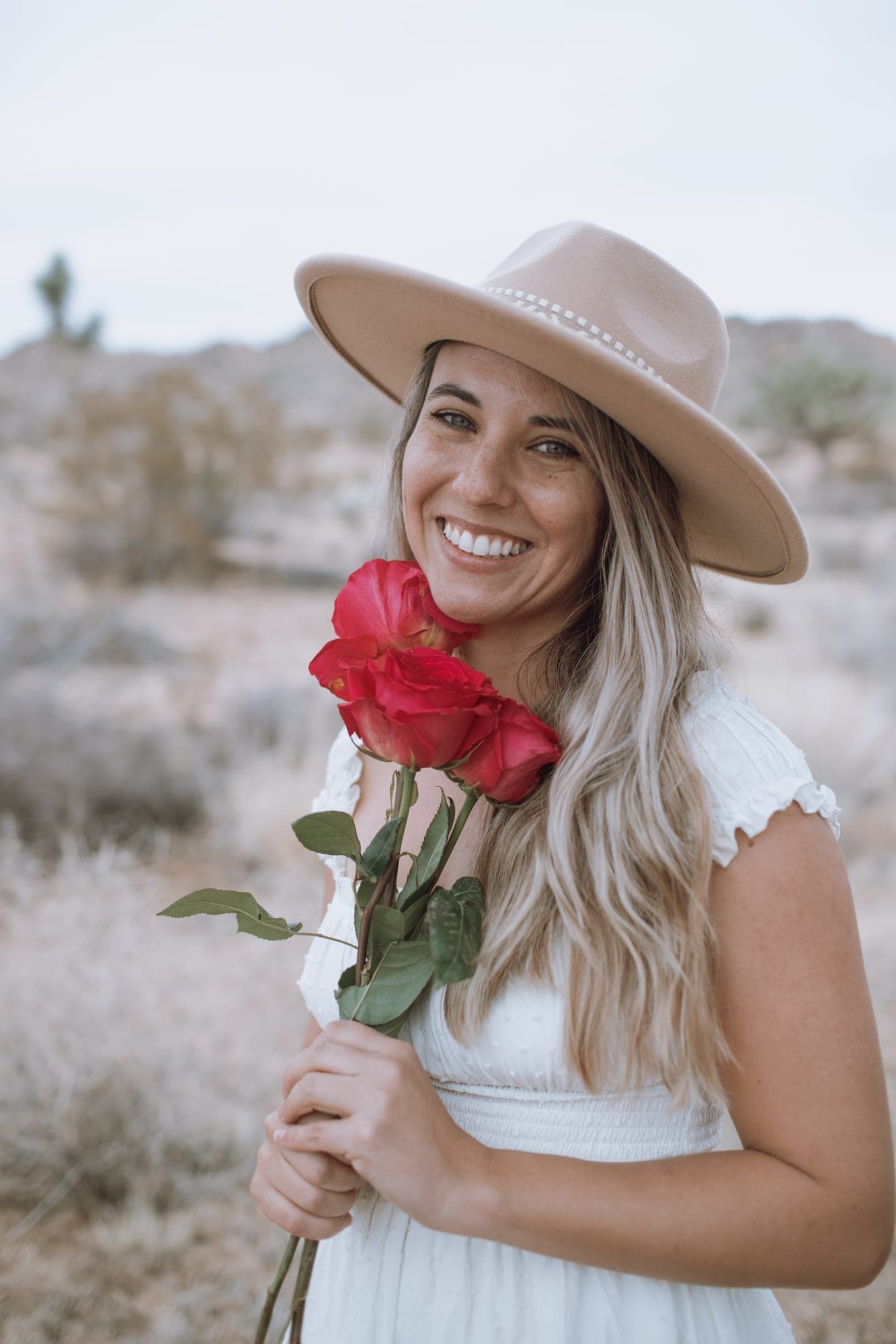 Portrait of Tori wearing a hat, holding roses